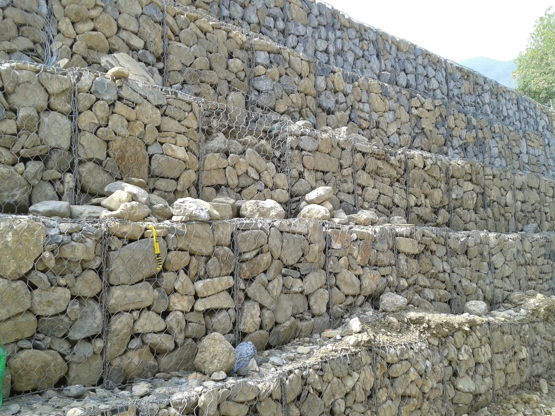 Stacked stone wall made of large rectangular blocks arranged in rows, showing a dry stone construction technique
